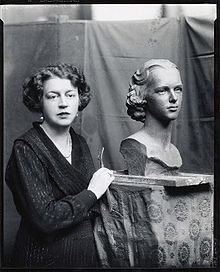 Margeret Cresson standing beside a bust of Nathalie Osborn.