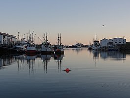 Båtar i hamnen i Sørvær (vänstra fotot 2013 och högra 2015).