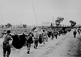Soldiers carry bodies after the Bataan Death March (1942). About 20,000 Filipino POWs and 1,600 Americans died [12][13]