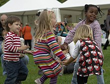 Young children dance in a circle