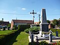 Le monument aux morts, avec au second plan un calvaire et à l'arrière-plan, le château d'eau.