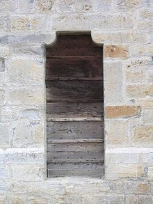 Vue d'une fenêtre au contrevent en bois.