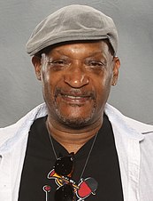 Tony Todd, um homem afro-americano, está olhando diretamente para a câmera e usando um chapéu.