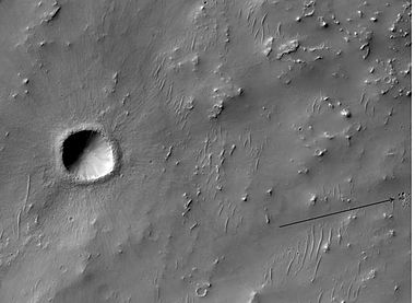 Recent small crater on floor of Dennin Crater, as seen by HiRISE. Arrow shows group of secondary craters from ejecta falling down.