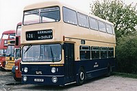 front quarter view of double-decker bus painted dark blue on the bottom and cream at the top