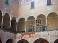 Il loggiato interno del palazzo Caffaro dei conti Lodron e alcune lapidi di monumenti funebri