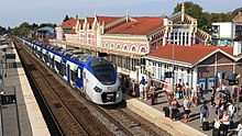 Train régional bimode composé de deux éléments de six caisses chacun, arrivant à quai par temps ensoleillé et devant une affluence voyageurs importante.