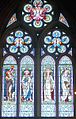The east window, Eaton Hall Chapel, designed by Frederic Shields (the altar unusually is at the west end), this shows the stained-glass of light colours that allow plenty of light through that Waterhouse liked, also his use of geometrical window tracery. The main figures depicted are John the Baptist, Saint Peter, James the Great and John the Apostle