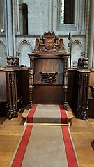 Photo de la stalle de l'archevêque surmonté d'un blason aux armes de Normandie porté par deux anges