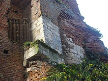 colonnes et morceaux de mur en pierre inclus dans une construction plus récente en brique foraine.