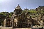 Stone church with a central tower topped by a conical roof.