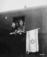 ניצולי מחנה בוכנוולד מניפים את הדגל הציוני בחלון רכבת בגרמניה, יוני 1945