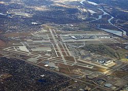 Aerial photograph of Minneapolis–St. Paul International Airport showing much of the unorganized territory of Fort Snelling. The historic fort is by the confluence of the Mississippi and Minnesota toward the upper right of the photograph, and Fort Snelling National Cemetery is at center right.