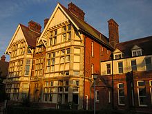 Two three-story gabled towers of East Kent College, in late sun