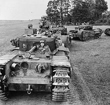 Photograph of a row of tanks with their drivers on road