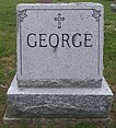 Grey granite stone engraved with the George family name and adorned with a cross
