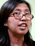 An Asian-American woman, wearing glasses, speaking.