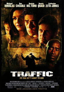 Film poster with five people shown from the neck up. The man on the left has his pointer finger pressed against his lips; the woman to his right has long hair and is smiling; the three men on the right have grim looks as they stare to the right. Below them are several vehicles and a man holding a gun that is getting shot. The top of the image includes the starring credits, while the bottom includes the title of the film and the main credits.