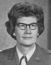 Middle-aged white woman wearing glasses and uniform.