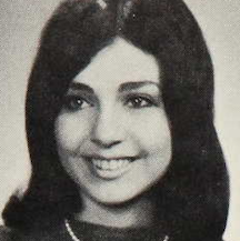 A smiling young white woman with dark hair and eyes