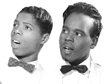 Promotional photograph of two mean in light-colored shirts and dark bow ties.