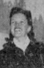 A smiling young white woman with dark hair, photographed outdoors