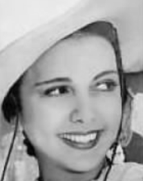 A smiling young woman with olive skin, dark eyes, wearing a white hat
