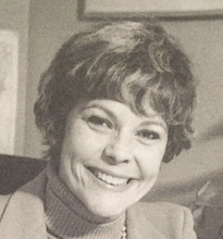 close up sepiatone headshot of a short haired white woman smiling at the camera