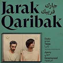 A photo of the two artists in white t-shirts in the bottom-right corner of a green field, with the album's name written at the top in both English and Arabic, and the artist's names written the same in the bottom-right.