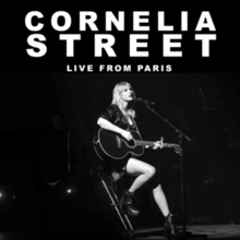 A black-and-white photograph of Swift playing the guitar. The white text "Cornelia Street Live from Paris" is written above her.