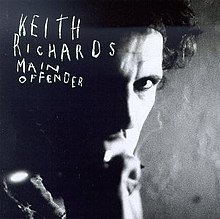 Black and white close-up photograph of Richards' face, brightly lit on right side of picture, hidden in shadow on left side, with KEITH RICHARDS MAIN OFFENDER in white scribbled capitals in top left quarter of album cover