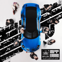 A photo from above of a blue sports car with the band members stood around it looking up at the camera