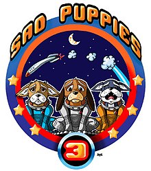 A mission patch, laid out like an Apollo mission patch with three cartoon sad puppies, in spacesuits but no helmet, in the foreground, and a crashing rocket behind them, against a backdrop of crescent moon and stars