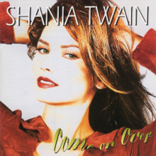 Photograph of a woman standing in front of a white background. She is wearing a red shirt and holding her hands in her hair, with her mouth ajar. The words SHANIA TWAIN are written at the top of the image in white capital letters. The words Come on Over are written at the bottom of the image in yellow cursive-style letters.