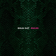A photo of a nonspecific reptile's green scales, vertically symmetrical. The singer's name "Doja Cat" is shown in white at the center of the image. Beside it is the song title "Rules", shown in pink.