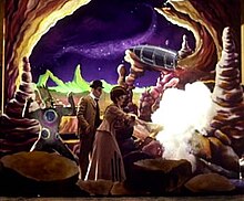 The set from the "Tonight, Tonight" music video features the performers dressed in Victorian clothing on a colorful set mimicking the moon. A moon monster is portrayed by a man on the left of the photo; he has on a pale green form-fitting jumpsuit with large blue and purple dots on it and wears matching make-up. On his head is a large prosthesis mimicking tall pale green hair. A man stands to the right wearing a suit and bowler and in front of him is a woman wearing a flowing gown. The woman has just struck another moon monster with an umbrella, and the moon monster has disappeared in a puff of smoke.