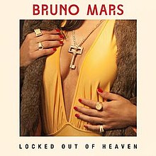 A key in between a woman's breasts, she also has several rings in her fingers and her finger nails painted in red. The word "Locked Out of Heaven" with capital font can be seen on the bottom of the picture, while the words "Bruno Mars" in red capital font are on the top of the image.
