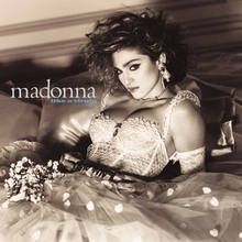 A sepia-toned image of Madonna in a wedding dress, with a belt with "Boy Toy" inscribed on its buckle.