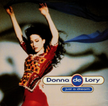 Donna de Lory wearing a red patterned dress with her arms above her head. The single name is written beside her image.