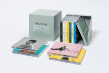 A photo of the box set opened. There is a CD case for all singles, with packing similar to their original releases. A special case is also included for the compilation's extras, titled In Gratitude.