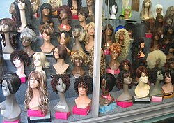 An assortment of wigs in display cabinet