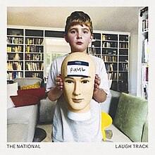 A photo of a boy holding a mannequin head which has a name tag on it reading "pauL"