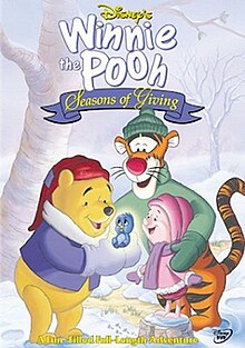 Pooh holds Kessie in brighten, he, Piglet and Tigger watches in happiness. A forest covered in snow view is behind them.