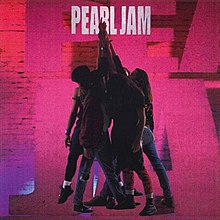 The band members have their hands raised up and holding another one's hand. In the background, a set of red-purple colored bricks with a cut-out of the name "Pearl Jam".