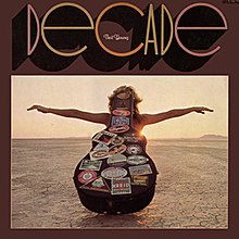 Stylized text "Decade" at the top one third, photo of a guitar container and a person at the bottom two-thirds