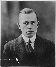 Photograph of a young man, his hair slicked and parted to the left, in a formal suit.