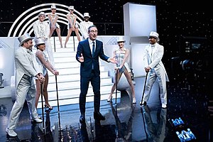 John Oliver and several dancers performing on stage