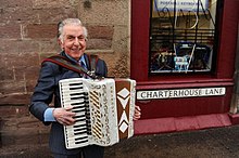Wilkie playing his accordion outside his shop in Perth city centre
