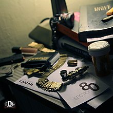 A desk with various objects on it. These includes books, a bible, a medicine container containing medical cannabis, bullets, a pipe, money, lipstick, a lamp, a lighter, and used marijuana rolls. A large paper reads "KENDRICK LAMAR" with his last name written in bold letters. Another brochure reads "SECTION 80" with the number 80 written in bold letters. The record label's logo is placed on the bottom left.