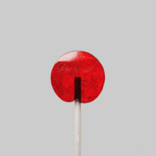 A red lollipop against a white-grey background